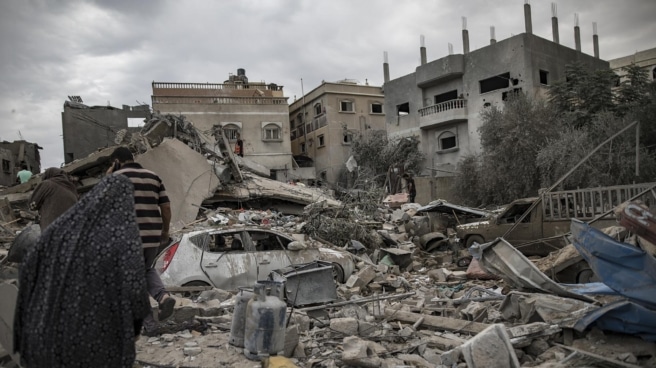 Palestinos buscan cuerpos y supervivientes entre los escombros de un edificio residencial tras un ataque israelí en Khan Younis, sur de la Franja de Gaza, 12 de noviembre de 2023.
