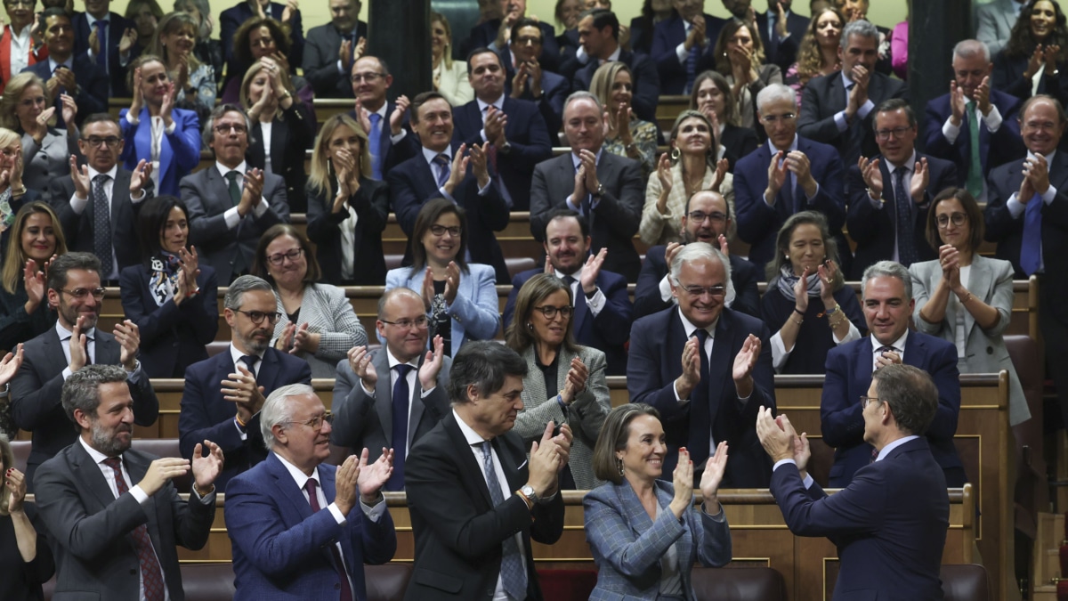 El líder del Partido Popular, Alberto Núñez Feijóo (d), recibe los aplausos de la bancada popular tras su intervención en el primer día del debate de investidura del presidente del Gobierno en funciones, Pedro Sánchez, este miércoles en el Congreso de los Diputados en Madrid.