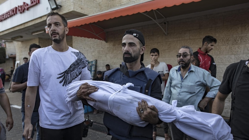 Un fotógrafo palestino sostiene el cuerpo de su hijo, fallecido en un ataque aéreo en el campo de refugiados de Maghazi
