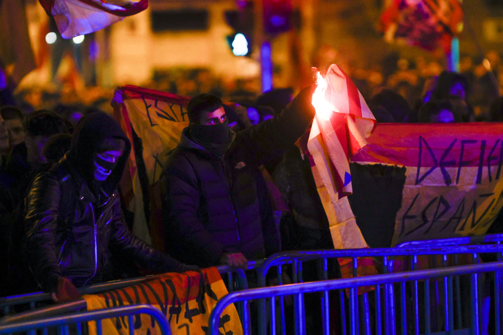 Una persona quema una bandera durante una concentración contra la Amnistía y la investidura tras el debate de investidura de Pedro Sánchez este miércoles, en la calle Ferraz, lugar de la sede central del PSOE en Madrid. 