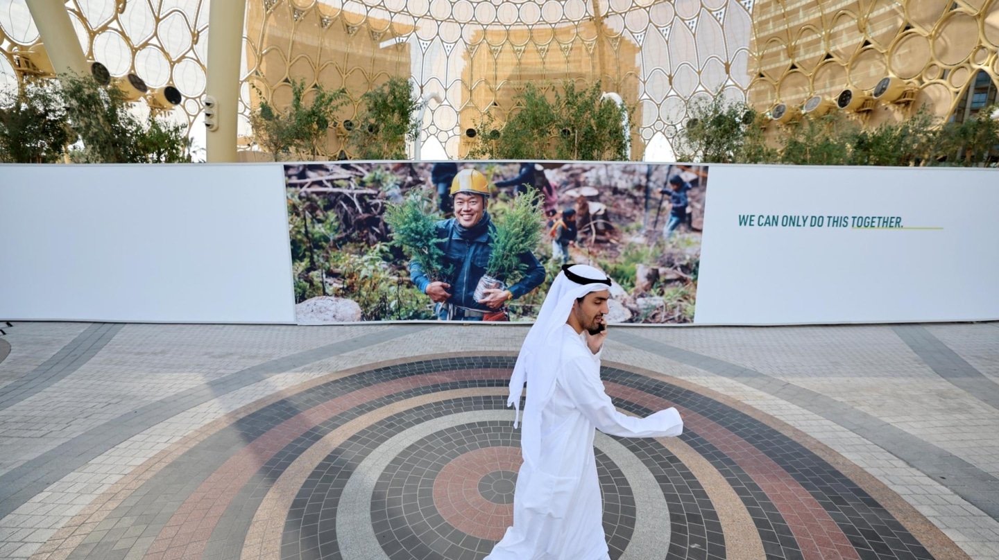 Un hombre para por la puerta de Expo Dubái, donde se celebra al COP28.