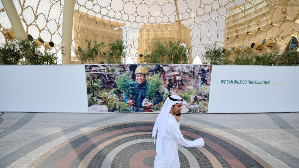 Un hombre para por la puerta de Expo Dubái, donde se celebra al COP28.
