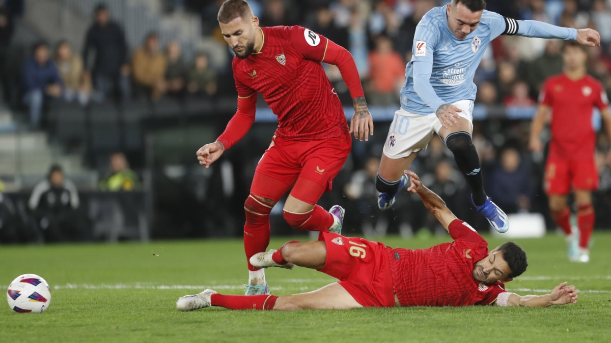 El delantero del Celta de Vigo Iago Aspas (d) disputa una posesión ante Jesús Navas (suelo) defensa del Sevilla durante el partido de la jornada 12 de LaLiga