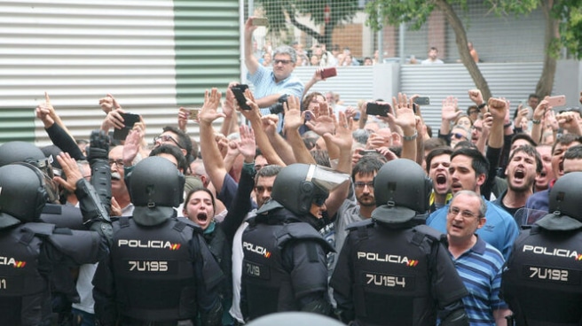 Agentes de la policía nacional forman un cordón policial en el exterior del IES Tarragona en el 1-O (Efe). Agentes de la policía nacional forman un cordón policial en el exterior del IES Tarragona en el 1-O (Efe).