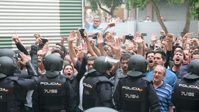 Agentes de la policía nacional forman un cordón policial en el exterior del IES Tarragona en el 1-O (Efe).