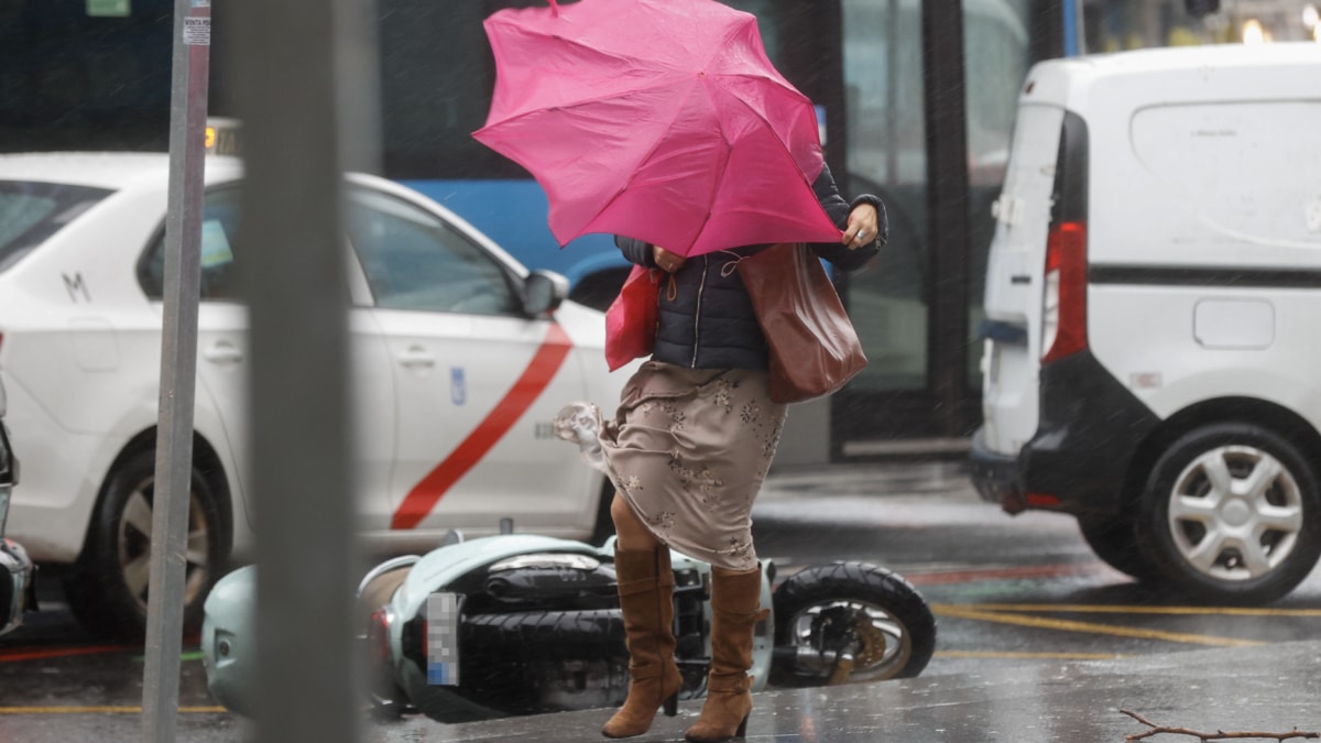Una viandante se enfrenta a las fuertes rachas de viento mientras camina por una calle del centro de Madrid (imagen de archivo)