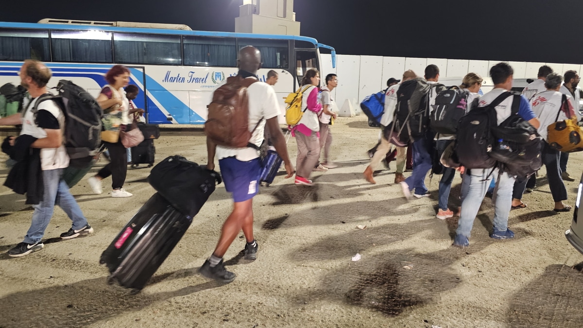 Varios extranjeros caminan después de pasar el cruce fronterizo de Rafah entre la Franja de Gaza y Egipto, en Rafah, Egipto, 01 de noviembre de 2023