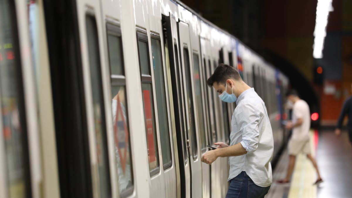 Un pasajero abre la puerta de un tren de Metro de Madrid