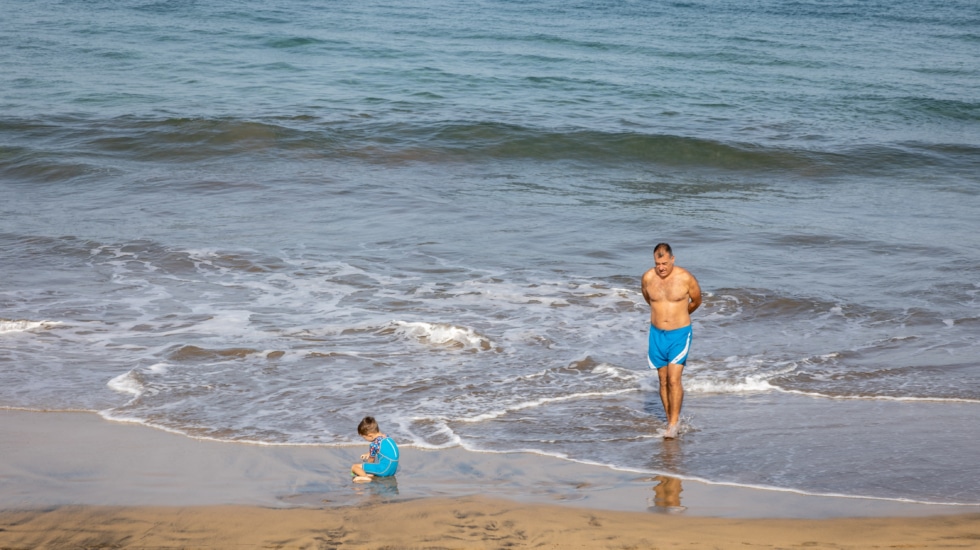 Varias personas en la playa durante la suspensión de clases por la ola de calor, a 11 de octubre de 2023, en Las Palmas de Gran Canaria