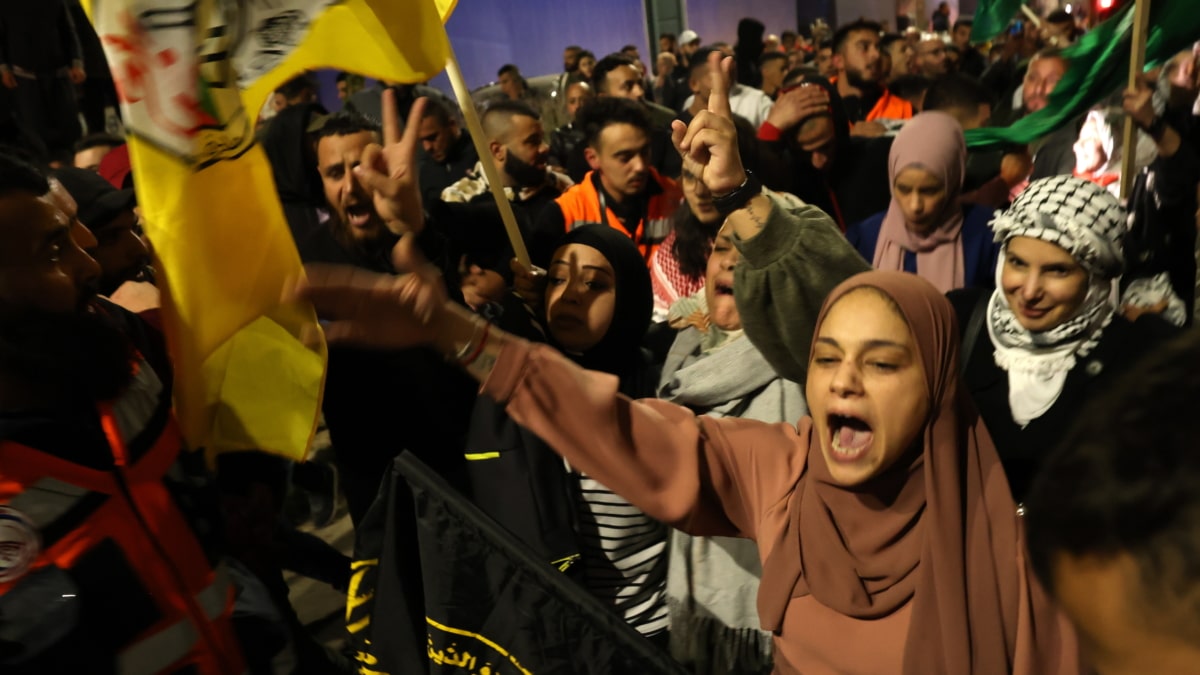 Los prisioneros palestinos recientemente liberados celebran con las multitudes que los esperaban, después de salir de la prisión militar Isareli Ofer, en la ciudad de Beitonia, cerca de Ramallah