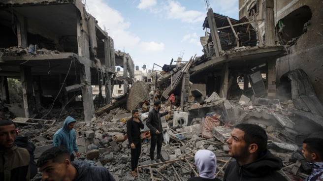 Los palestinos inspeccionan los escombros de una estructura destruida tras los ataques aéreos israelíes en la ciudad de Rafah, en el sur de la Franja de Gaza