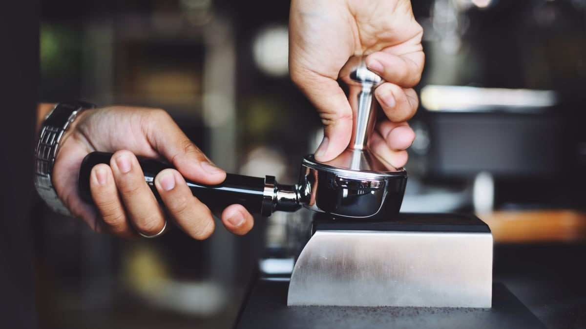 Un camarero retira los posos del café