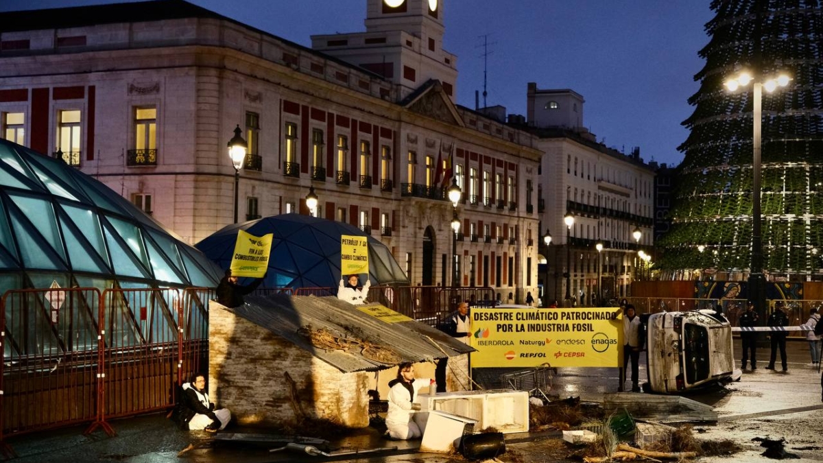 Greenpeace coloca un coche destrozado por la DANA en la Puerta del Sol para protestar contra los combustibles fósiles