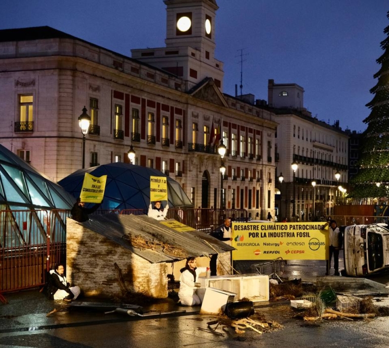 Greenpeace coloca un coche destrozado por la DANA en la Puerta del Sol para protestar contra los combustibles fósiles