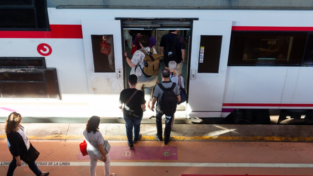 Varios viajeros suben a un tren de Cercanías de Renfe.