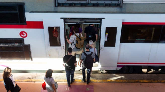 Varios viajeros suben a un tren de Cercanías de Renfe.