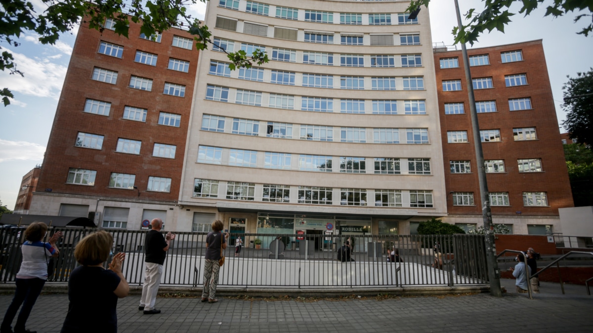 Sanitarios y varios transeúntes aplauden en la puerta del Hospital Fundación Jiménez Díaz