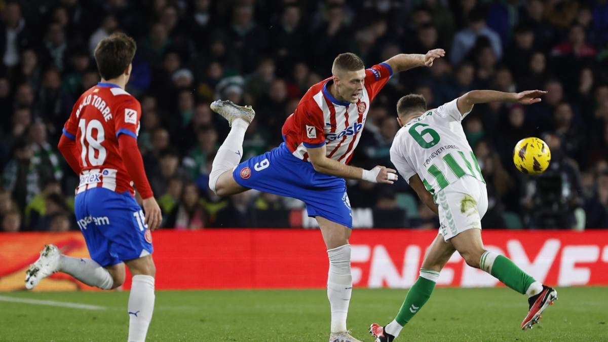 El defensa del Real Betis Germán Pezzella (d) disputa una posesión con el delantero ucraniano del Girona FC Artem Dovbyk (c) durante un encuentro correspondiente a la jornada 18 de LaLiga