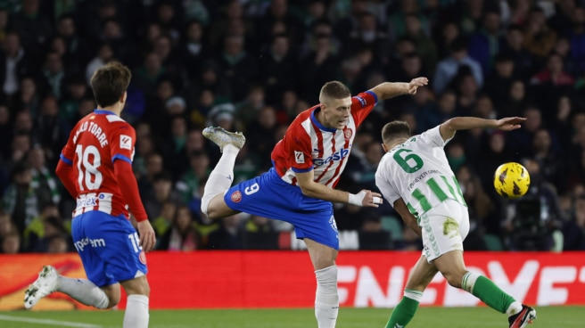 Betis defender Germán Pezzella (g) argues about possession of the ball with Girona's Ukrainian striker Artem Dovbik (c) during the match of the 18th round of La Liga.