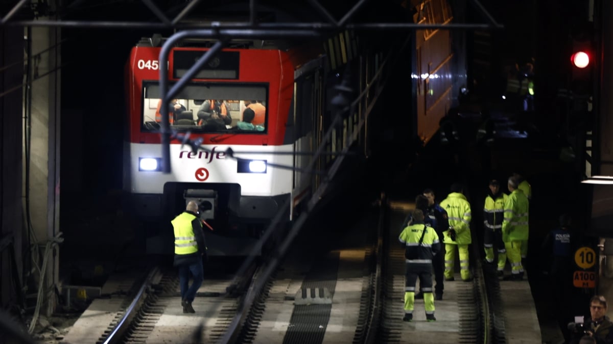 Varios operarios junto al tren de Cercanías que ha descarrilado este martes