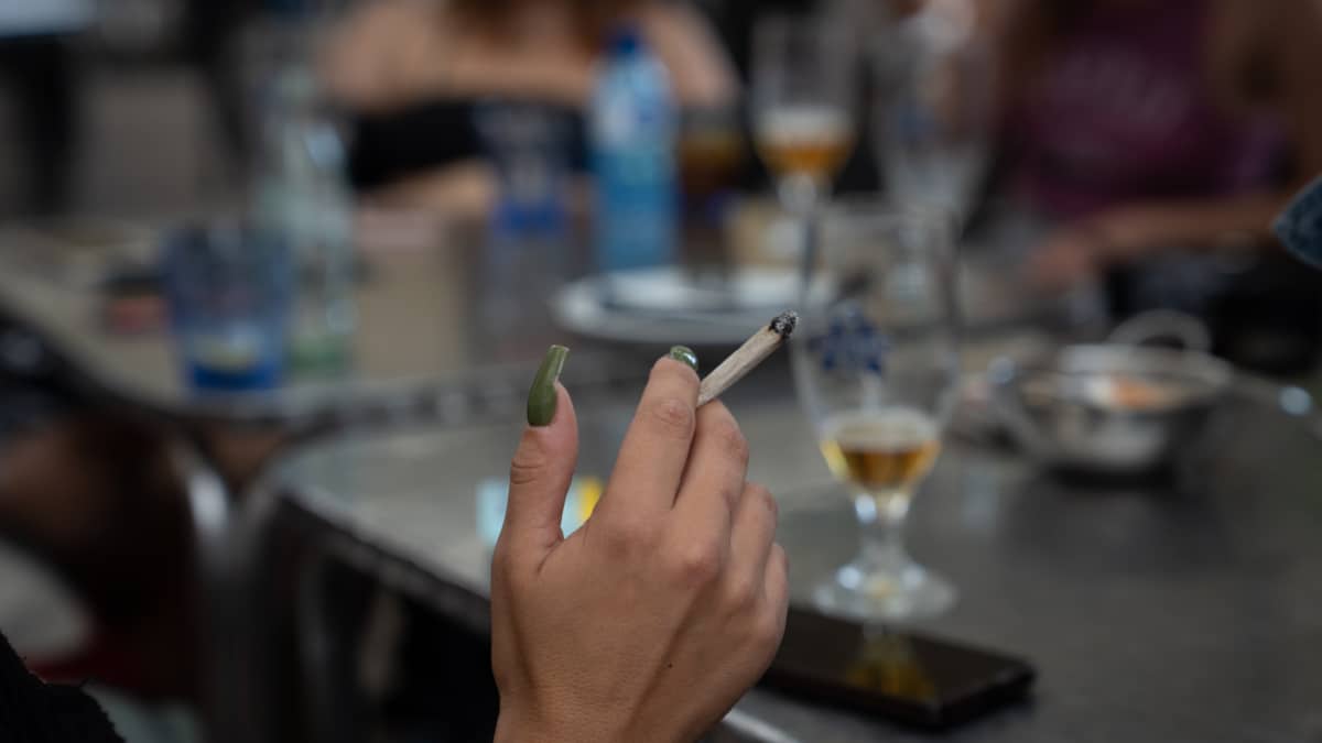 Una mujer fuma en la terraza de un bar