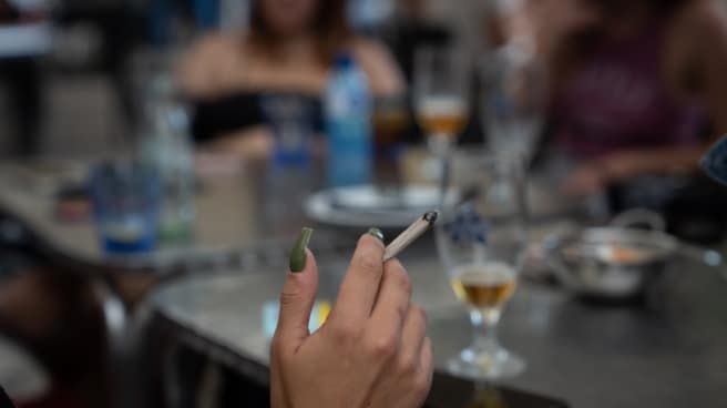 Una mujer fuma en la terraza de un bar