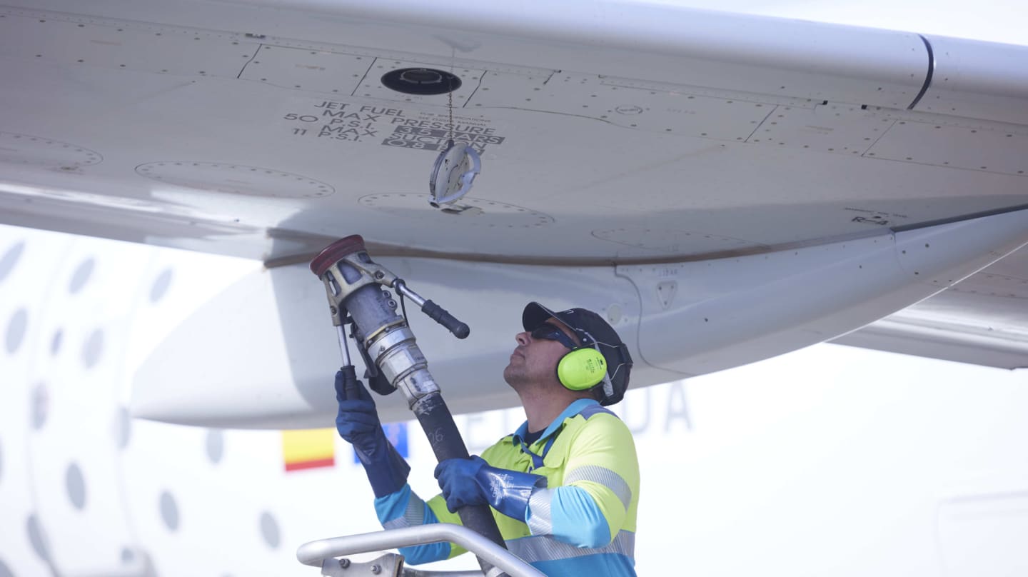 Un operario realiza la maniobra para recargar un avión con biocombustible sostenible de segunda generación.
