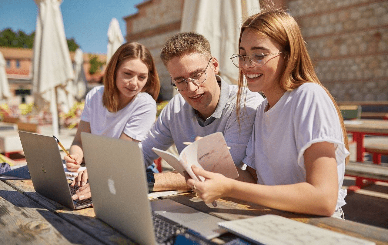 Estudiantes trabajando delante de un ordenador.