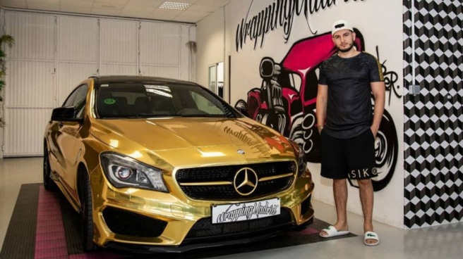Omar Montes junto a su Mercedes CLA deportivo en color dorado.