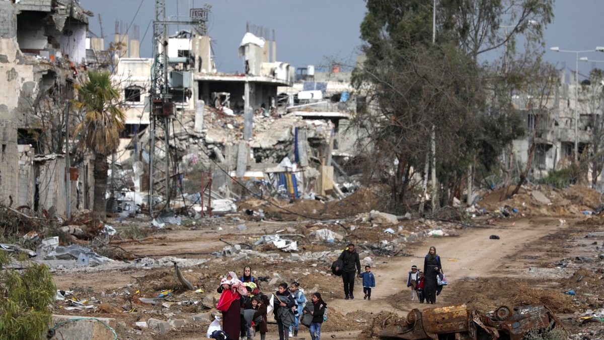 Familias palestinas caminan después de cruzar desde de norte a sur la Franja de Gaza, a lo largo de la carretera Salah Al Din este martes.