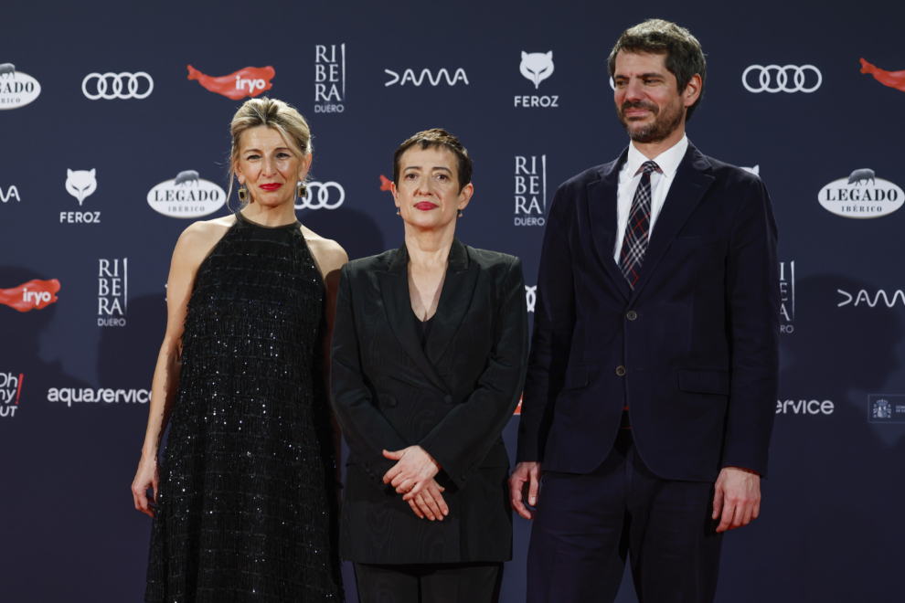 La vicepresidenta segunda, Yolanda Díaz (i), María Guerra, presidenta de la Asociación de Informadores de Cine de España (AICE), y el ministro de cultura, Ernest Urtasun Domènech (d), posan en la alfombra roja de los Premios Feroz