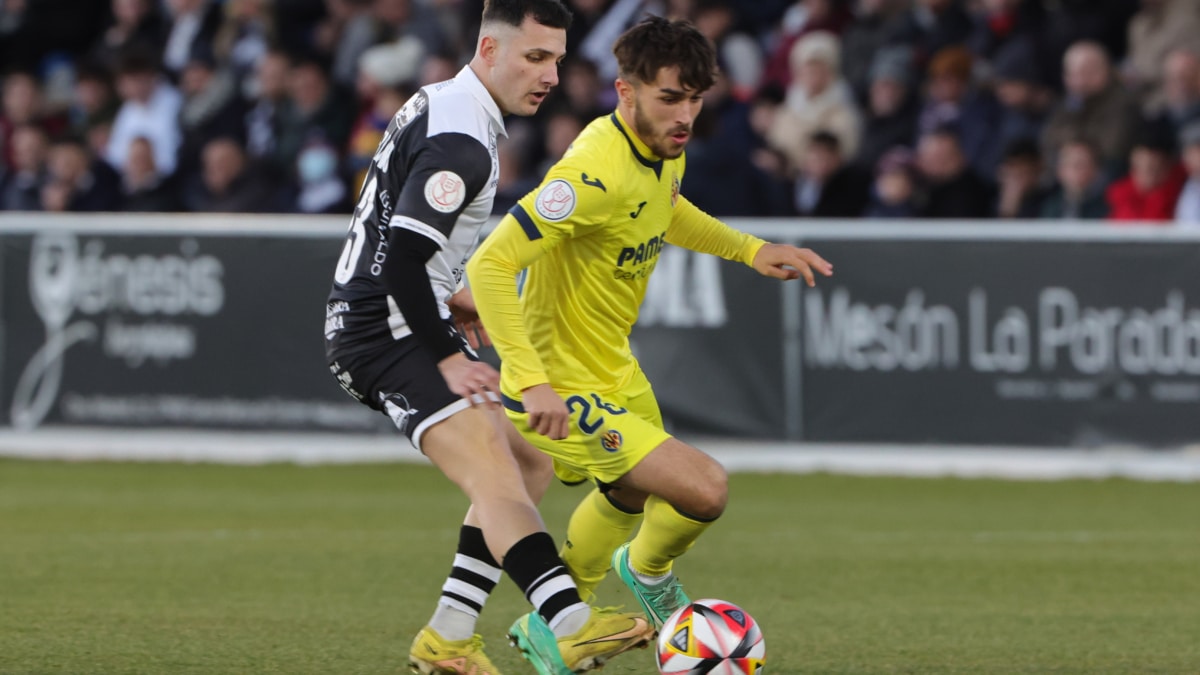 El defensa del Villarreal Adria Altimira (i) se escapa de Juan Serrano, de Unionistas de Salamanca, durante el partido de dieciseisavos de final de Copa del Rey