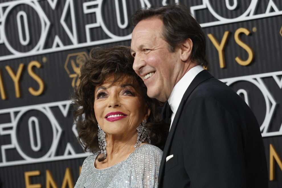 Joan Collins mira a su marido, Percy Gibson, 31 años menor que ella, en la alfombra roja de los Emmy.