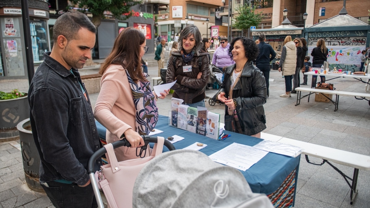 Una familia se informa acerca de la asociación Dame Teta durante la Fiesta de la Lactancia, en la Plaza Mayor, a 21 de octubre de 2023, en Albacete, Castilla-La Mancha (España).