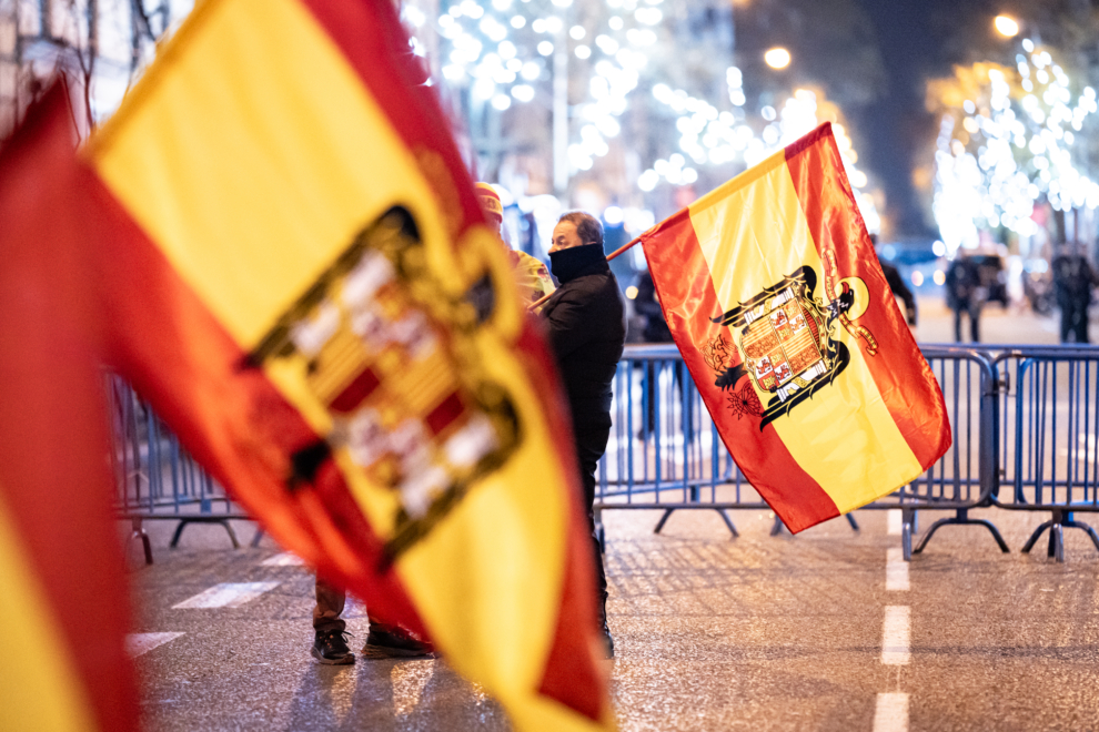 Varias personas con banderas españolas preconstitucionales celebra la entrada del año nuevo