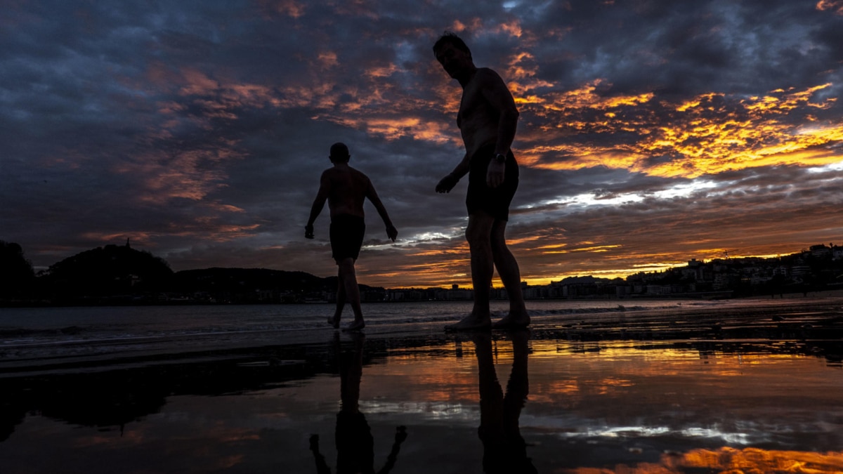 Dos hombres se bañan a primera hora de este lunes en la playa de Ondarreta de San Sebastián.