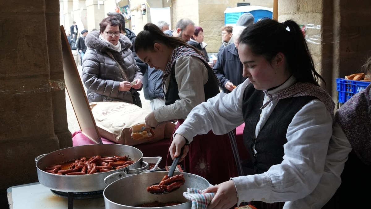 Dos jóvenes trabajan durante la feria agrícola de Santo Tomás, en San Sebastián.