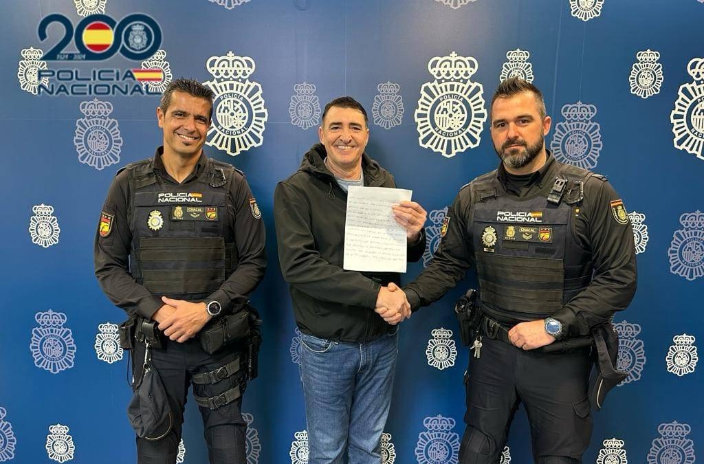 Dos agentes de policía posan con el hombre al que salvaron de asfixiarse con un torrezno en un bar de Alicante