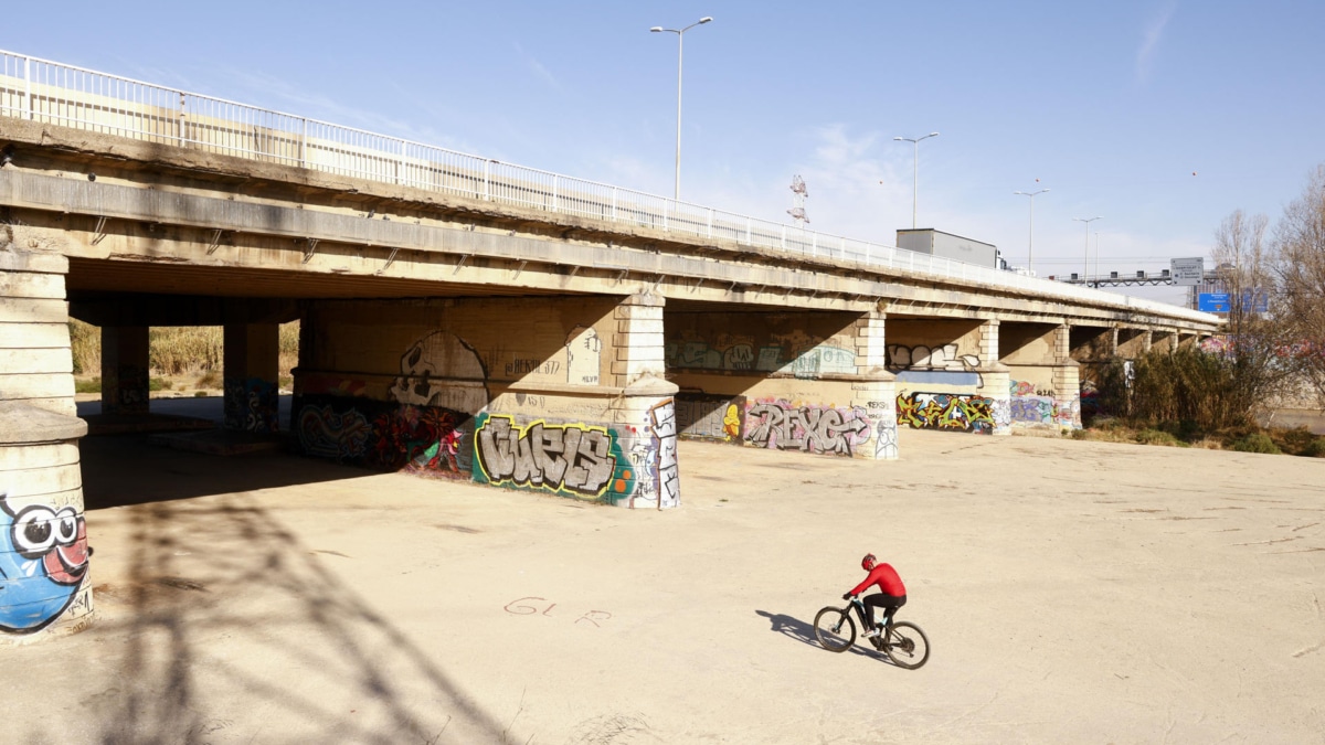 Un ciclista pasea en bicicleta por el margen urbanizado del rio Llobregat en El Prat del Llobregat.