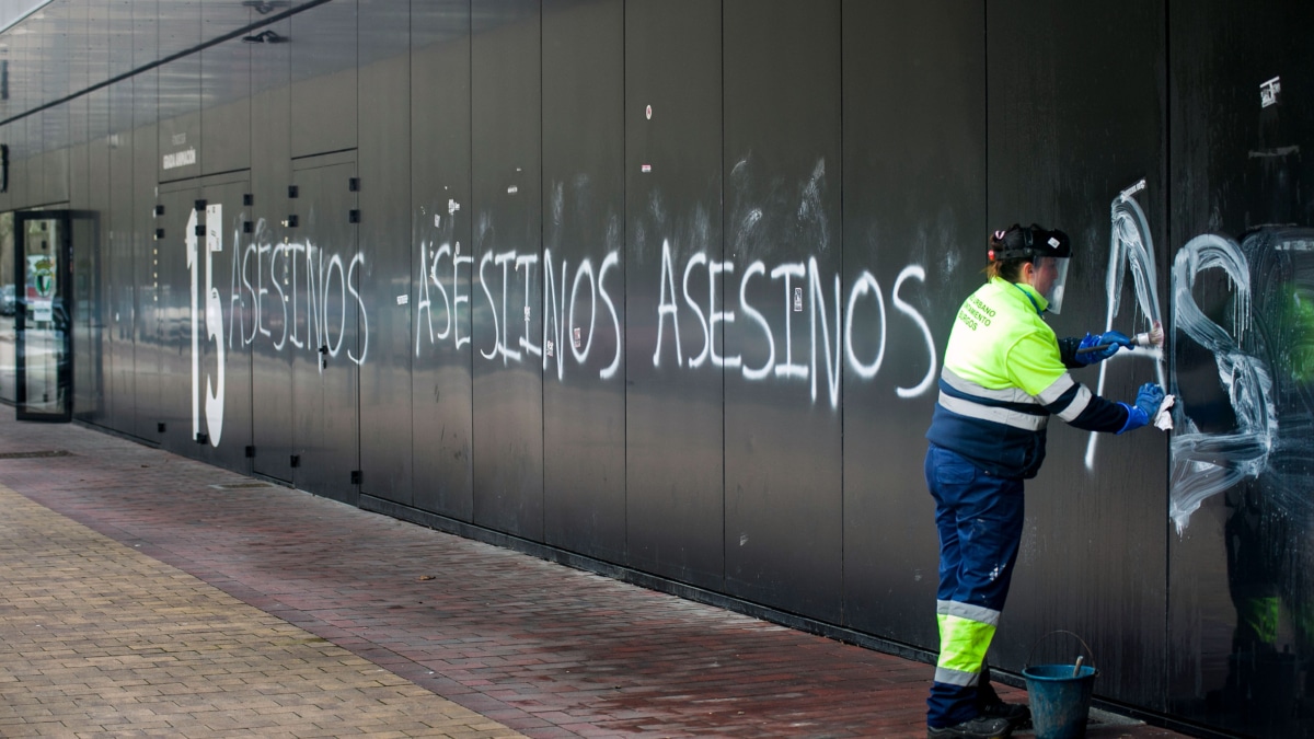 Trabajadora eliminando las pintadas de "asesinos" en la fachada del Estadio Municipal El Plantío (del Burgos CF)