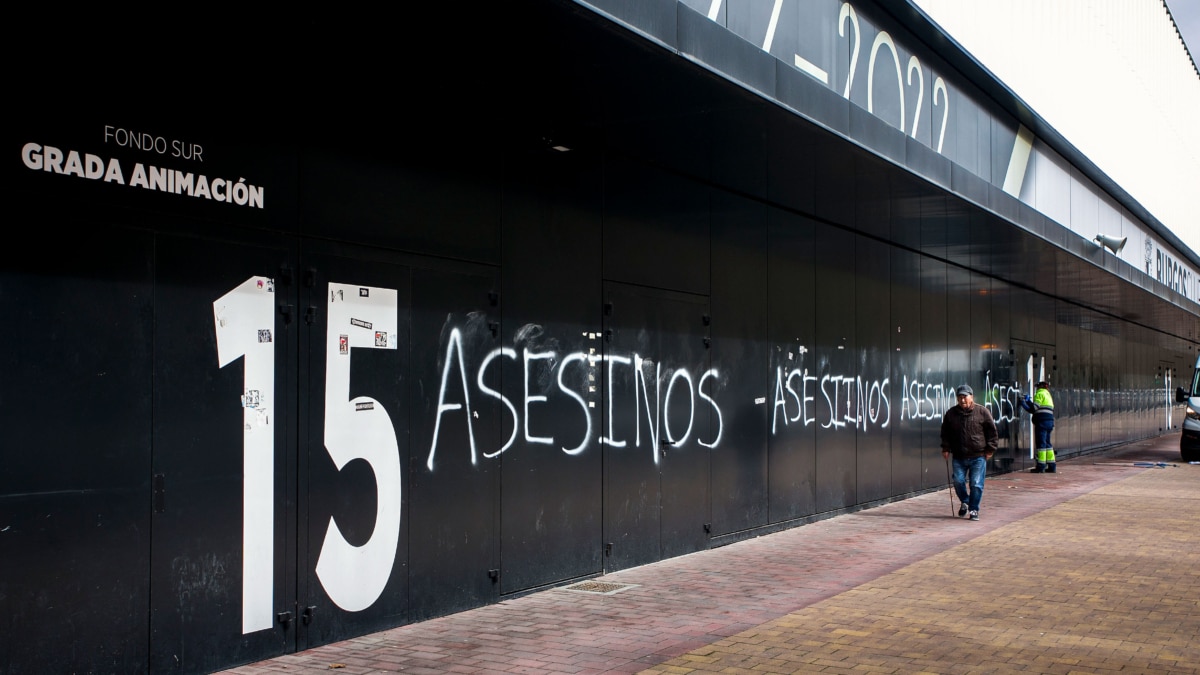 Trabajadora eliminando las pintadas de "asesinos" en la fachada del Estadio Municipal El Plantío, del Burgos CF.
