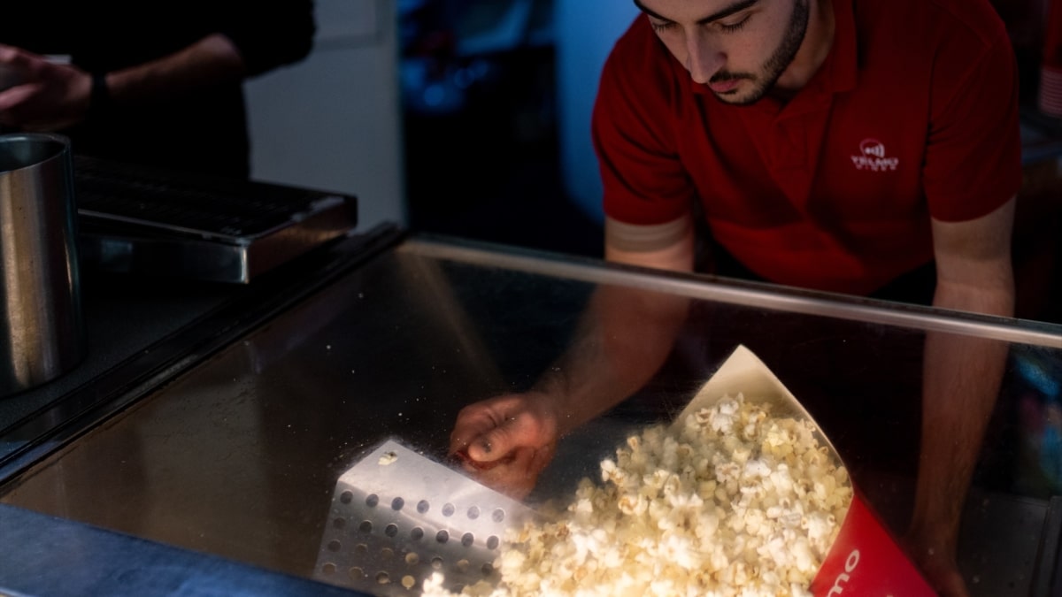 Un empleado prepara un cubo de palomitas antes de la última proyección del cine Comedia, en Barcelona.