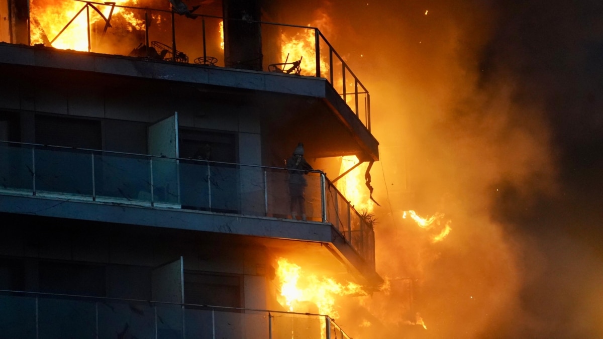 Una persona en un balcón del edificio en llamas, en el barrio de Campana (Valencia)