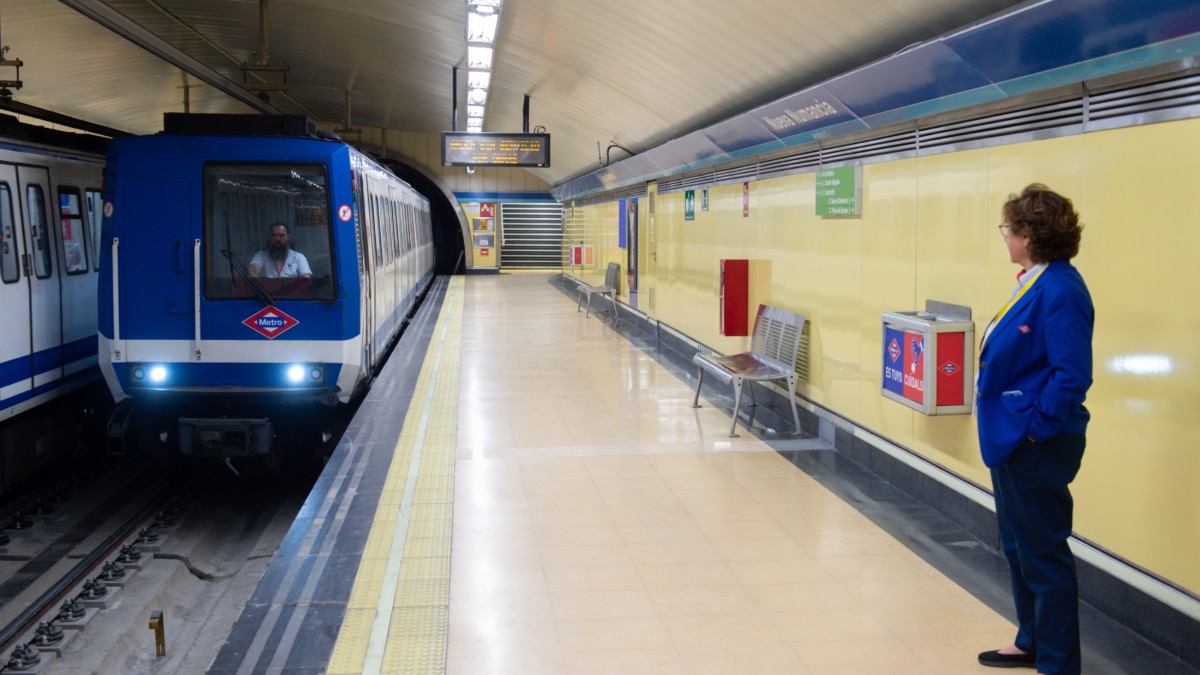 Una trabajadora de Metro de Madrid mientras llega un tren.