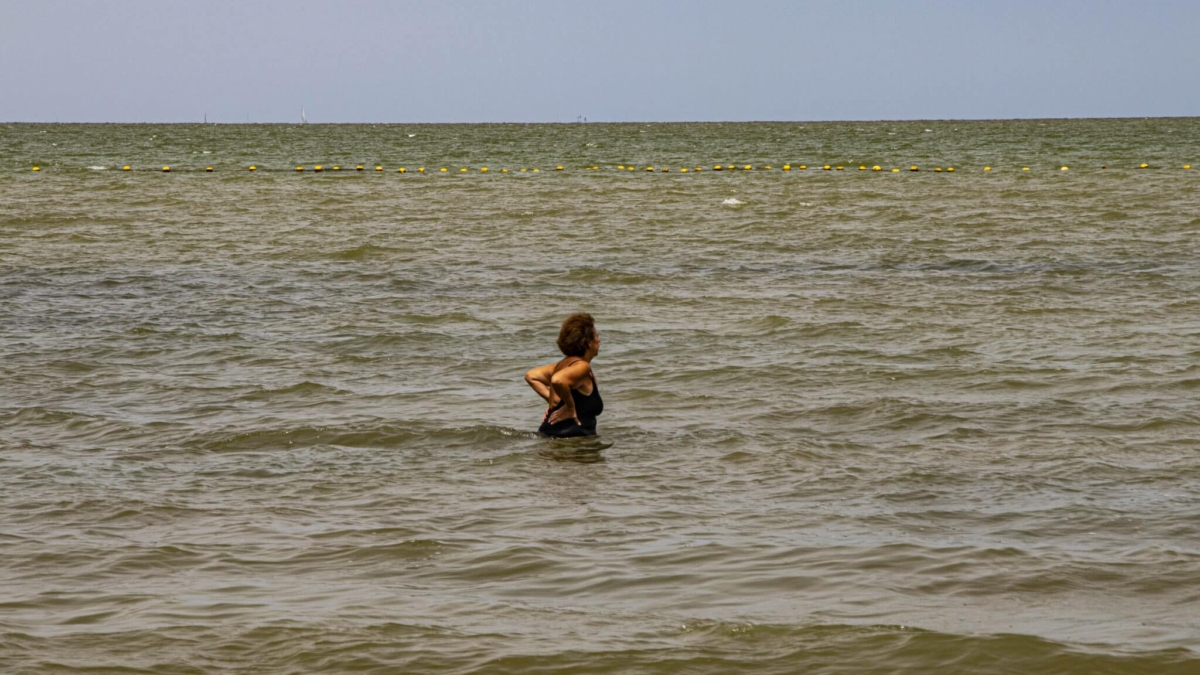 Una bañista en la playa de Los Urrutias en la laguna del Mar Menor, afectada por contaminación por nitratos.