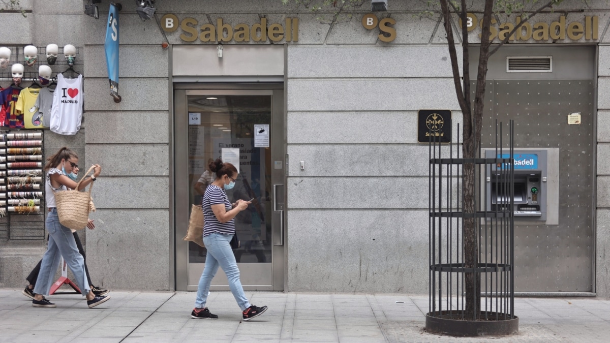 Varias personas pasan por una sucursal de Banco Sabadell