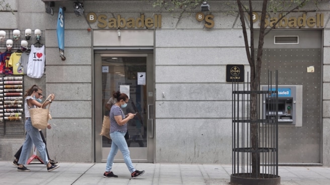 Varias personas pasan por una sucursal de Banco Sabadell