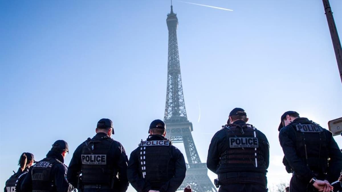 Varios agentes de la policía frente a la Torre Eiffel.