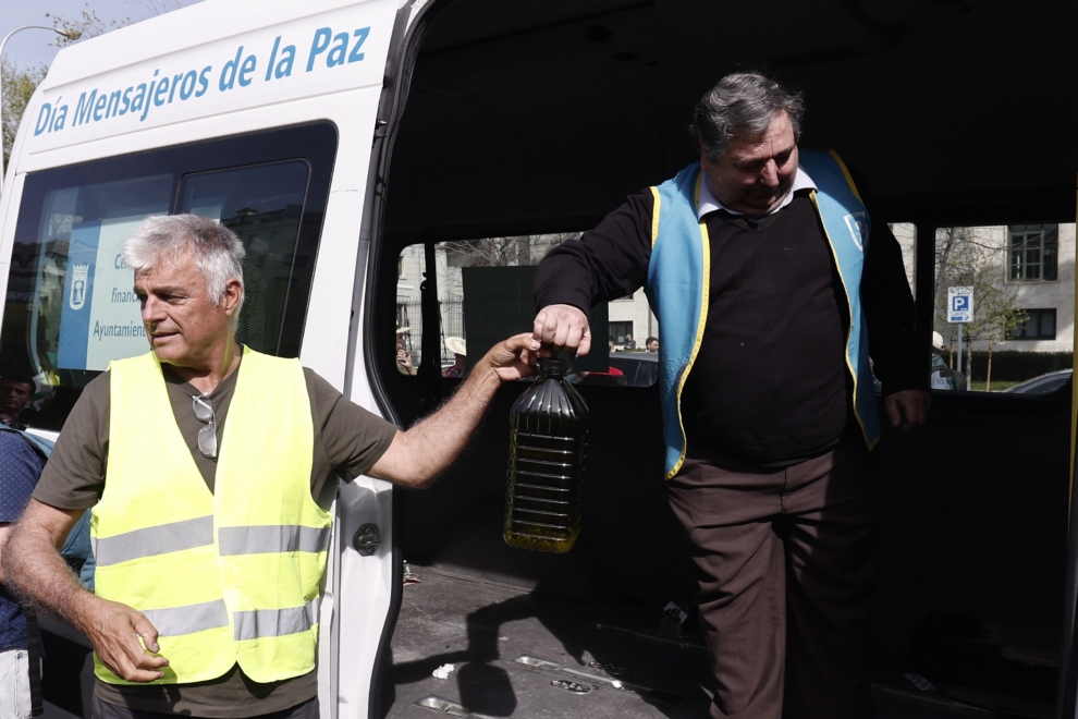 Luis Cortés (i), coordinador general de Unión de Uniones de Agricultores y Ganaderos, hace entrega de una donación de 125 litros de aceite de oliva a la ONG Mensajeros de la Paz