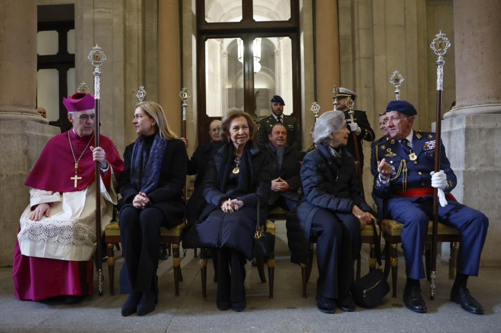 El arzobispo castrense Juan Antonio Aznárez, la infanta Cristina, la reina Sofía y su hermana Irene de Grecia momentos antes de la salida de la procesión del Santísimo Cristo de los Alabarderos, este Viernes Santo en el Palacio Real de Madrid. EFE/ Mariscal
